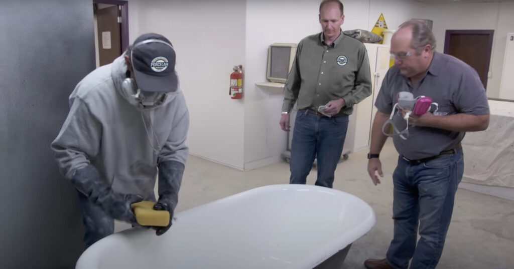 Technician applying a smooth refinishing coat to a bathtub in a Lowell, MA apartment bathroom