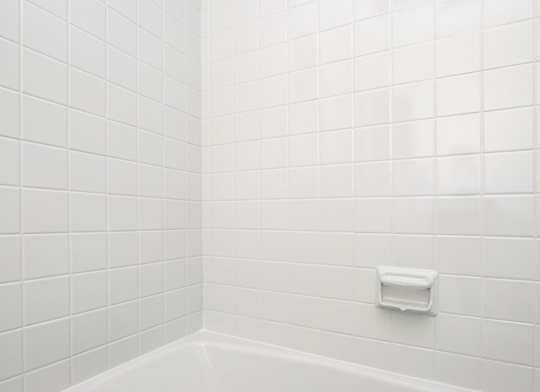 Technician refinishing a bathtub in a Somerville, MA apartment, ensuring a flawless new surface for renters