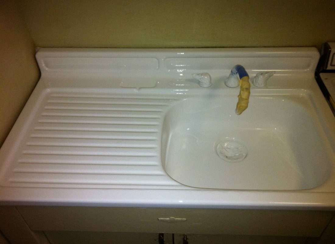 Technician using specialized tools to refinish a bathtub in a Framingham, MA condo bathroom, focused on detail and quality