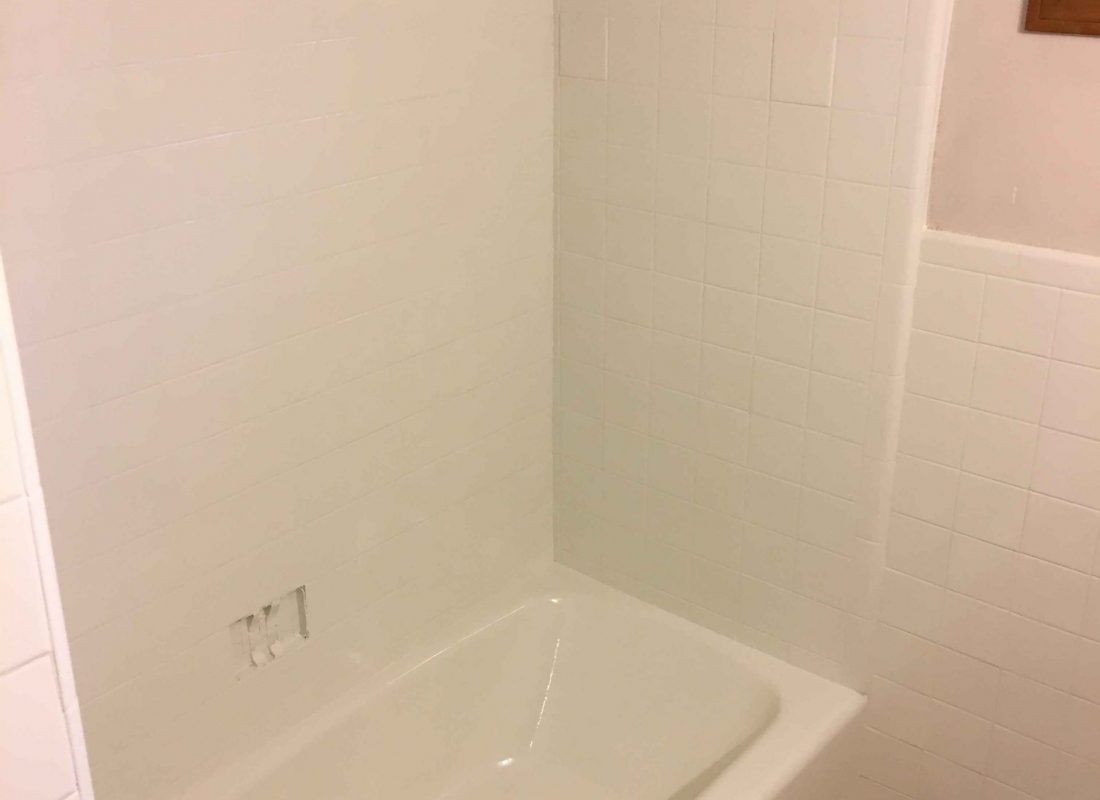 Refinishing expert restoring tile and tub surfaces in a busy Framingham, MA apartment complex bathroom